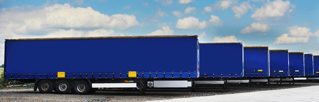 a row of large blue trailers lined up ready to be attached to lorries