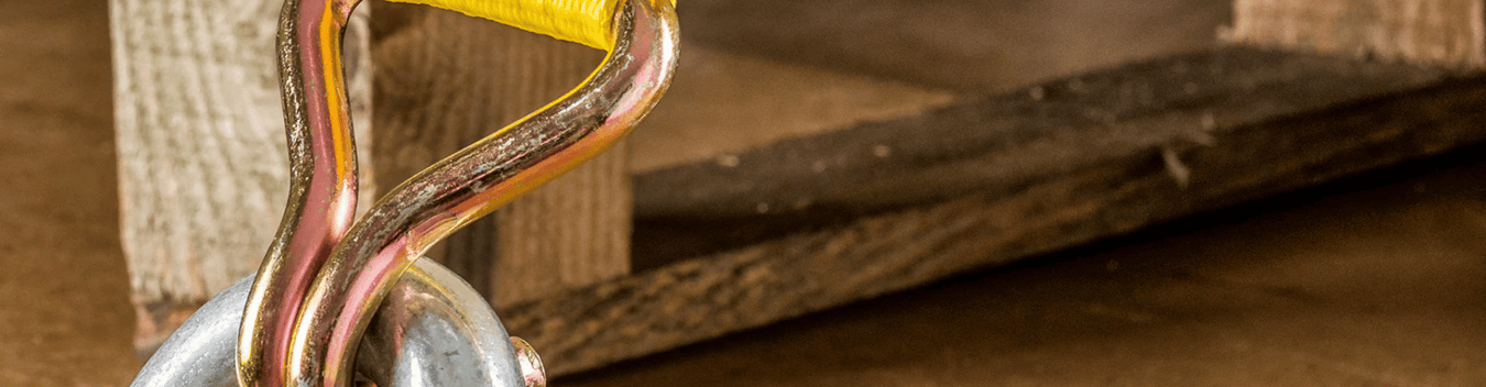 the end of a yellow taut strap with brass hardware