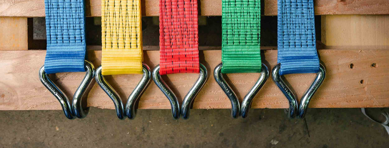 the end of a yellow taut strap with brass hardware