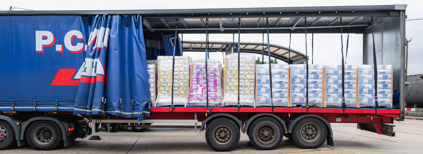 a line of large blue trailers waiting to be attached to lorries