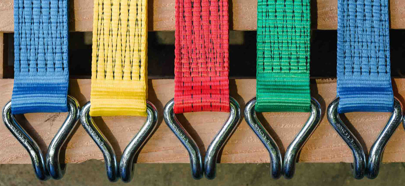 red, blue and orange taut straps fastened and lying next to each other with silver hardware
