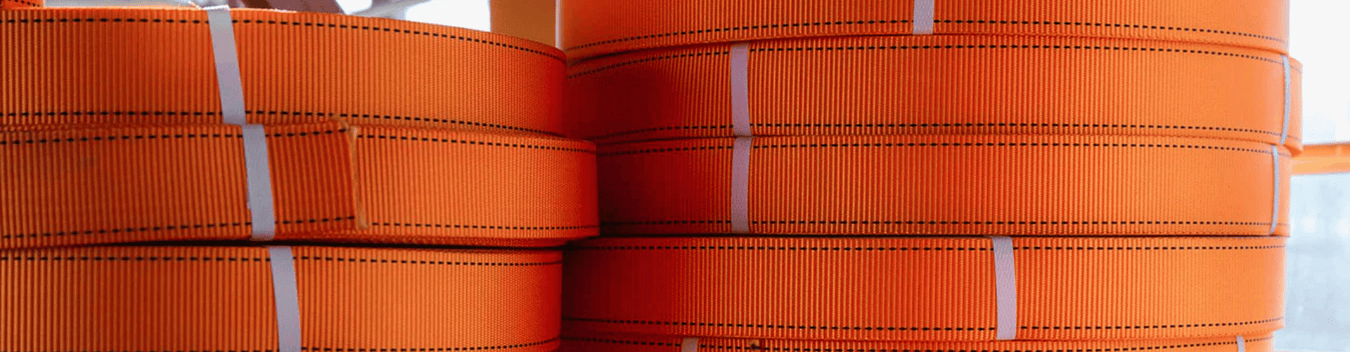 a close-up image of orange, pink, red and blue taut straps hanging vertically next to each other